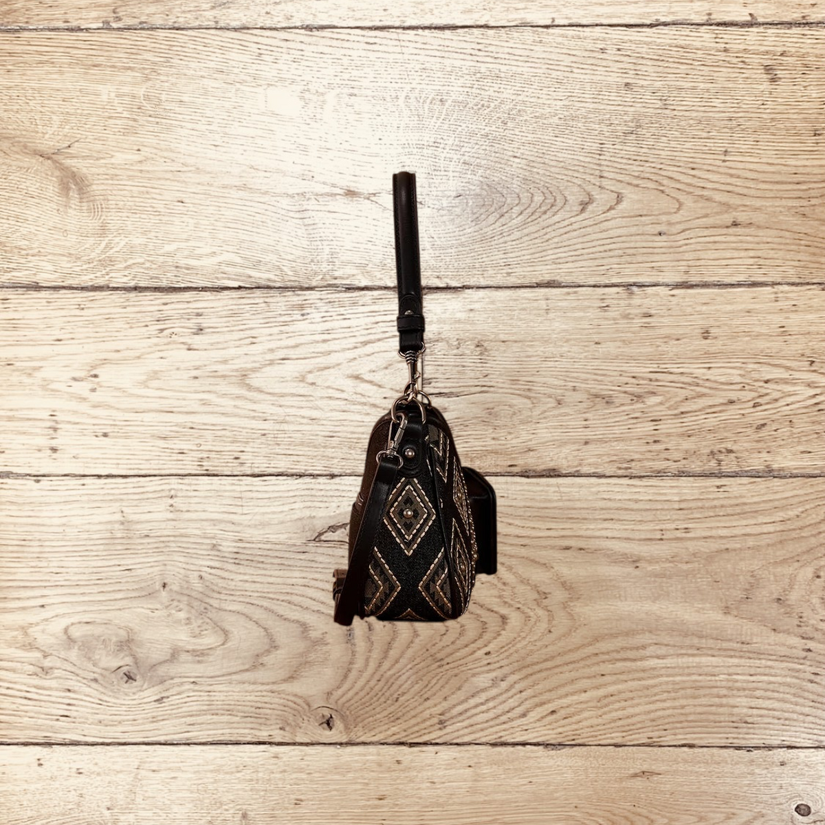 SugarBee's Western Boutique Wrangler black denim hobo bag with geometric embroidery and silver studs, side profile view.